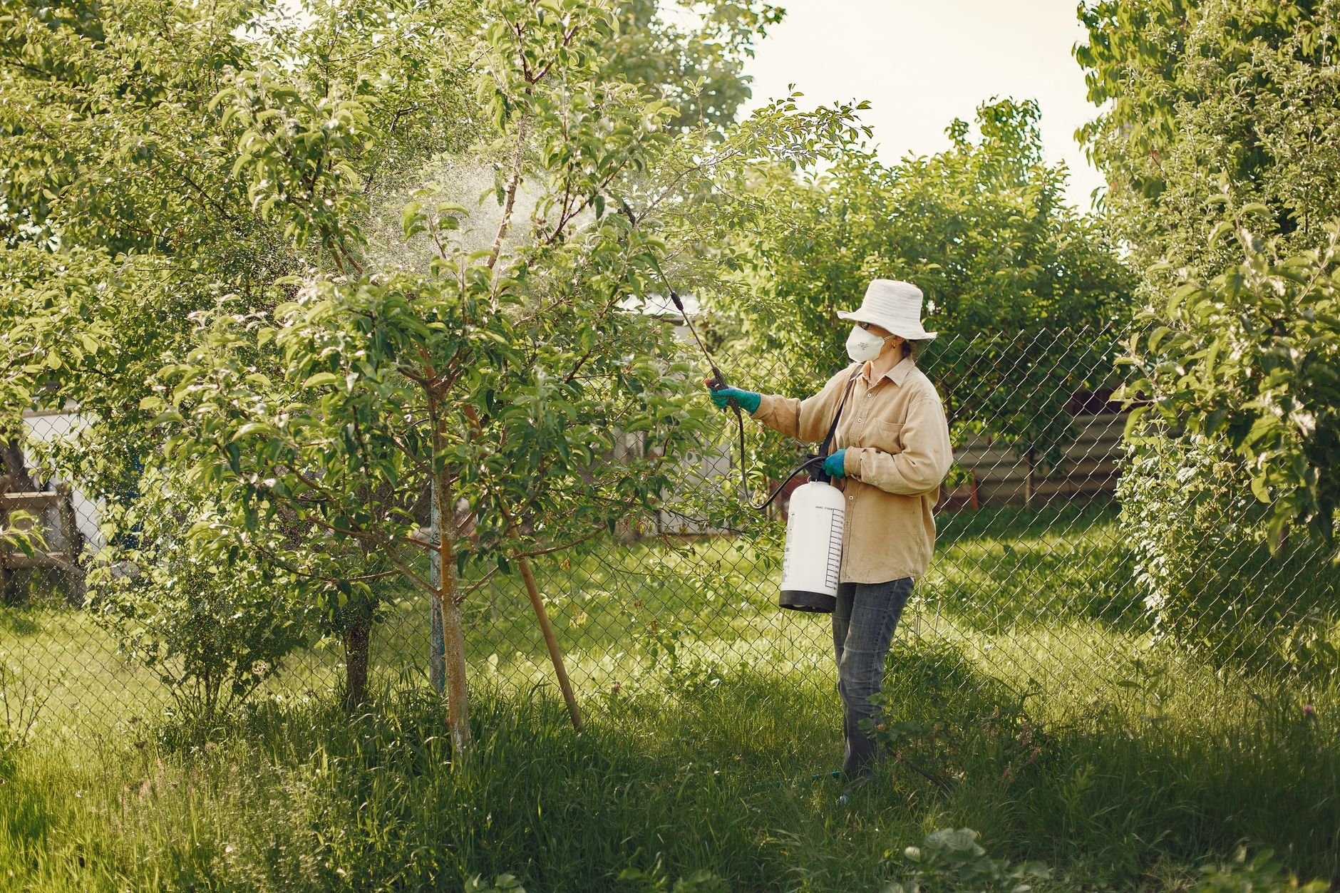 Pest control technician in protective gear treating a property